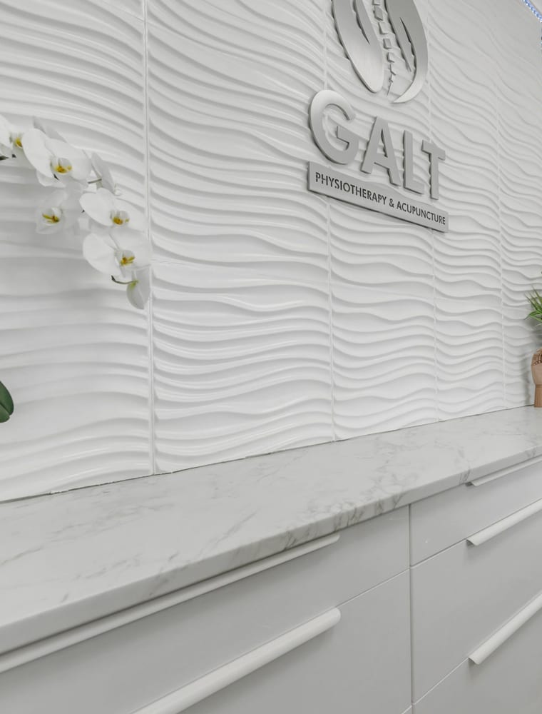 The clinic's own sign, mounted on the textured wall behind reception