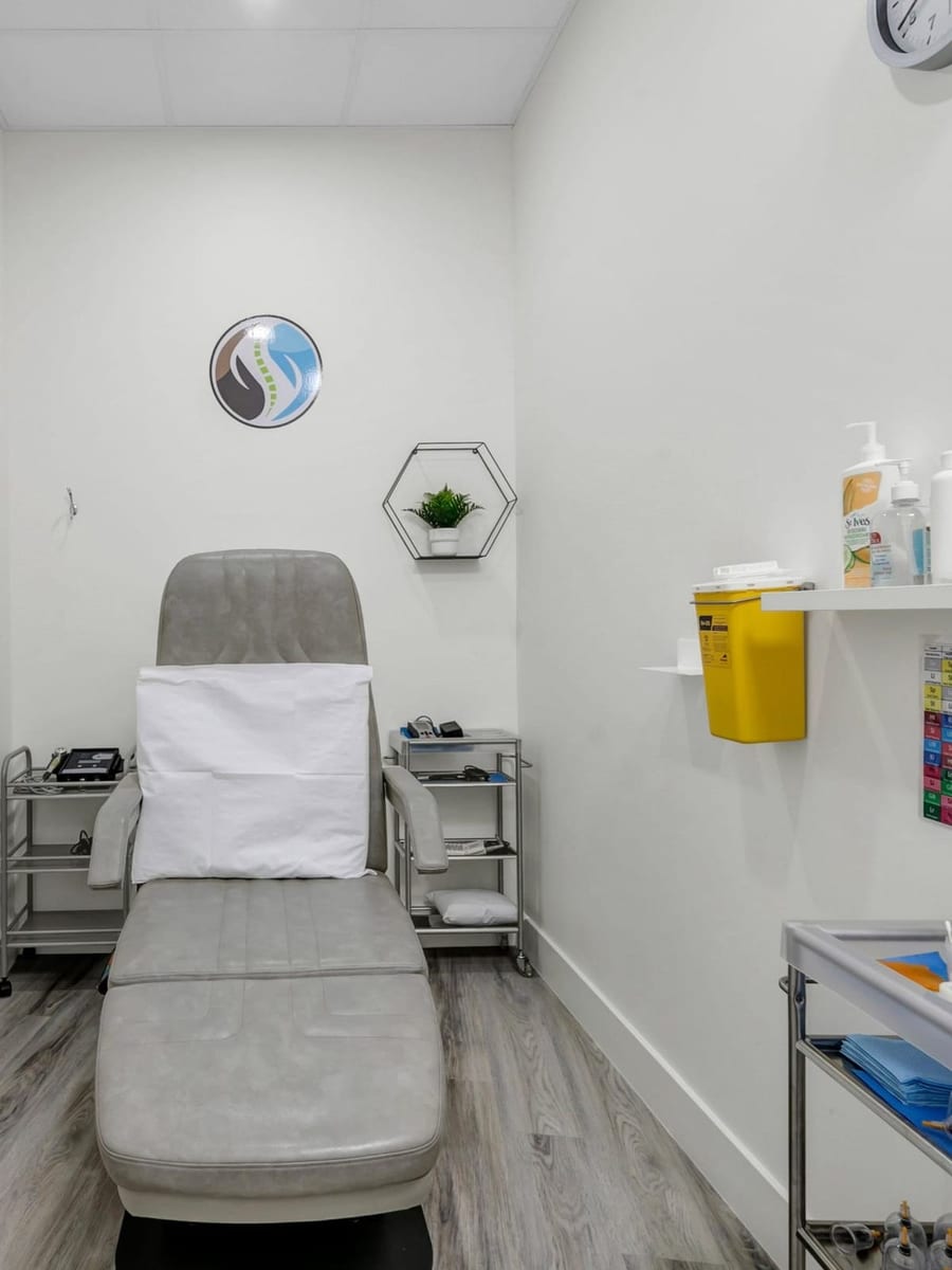 A treatment room at the clinic, with a reclining treatment chair below the clinic's own wall mark