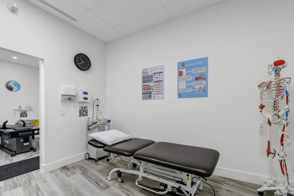 An acupuncture treatment room at the clinic, with a treatment table and an anatomical model