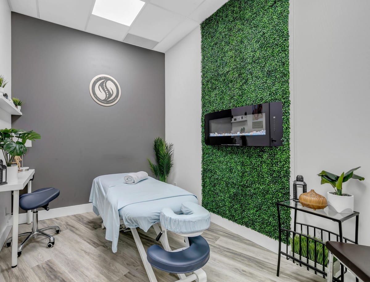 The massage room at the clinic, with a draped massage table beside a living wall